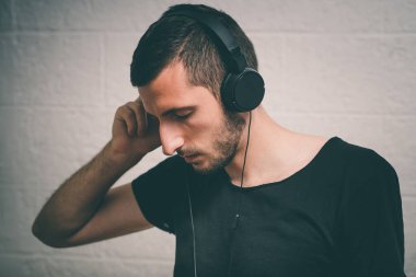Kulaklıklı bir adam stüdyo geçmişine karşı.