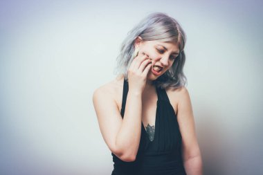 Diş ağrısı çeken kadın stüdyo geçmişine karşı