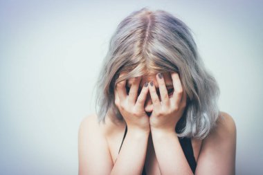  Kadın elini yüzünü kapatıyor.