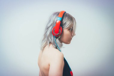 Stüdyo geçmişine karşı kulaklık takan kadın.