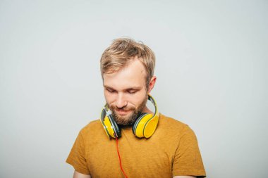 Kulaklıklı bir adam stüdyo geçmişine karşı.