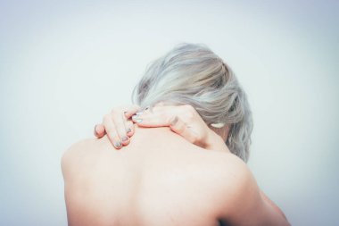 Kapalı portre mutsuz, kronik boyun ağrısı olan genç ve güzel bir kadın, uzun çalışma saatlerinden sonra kas burkulması, çalışmalar, izole edilmiş beyaz arka plan..