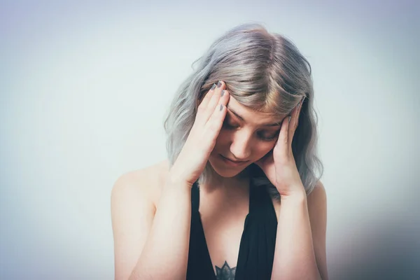 Headache woman against studio background