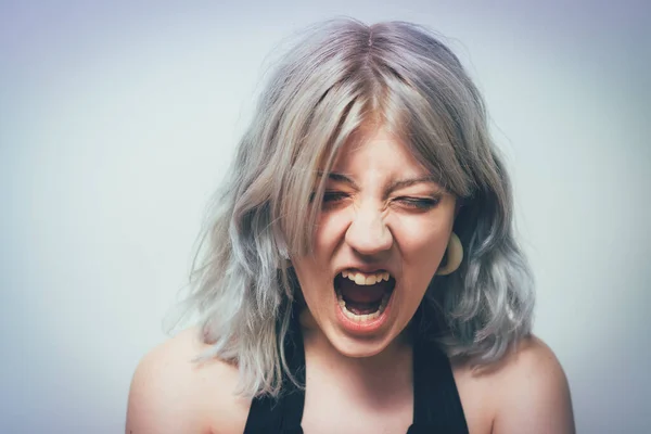 Angry screaming woman against studio background