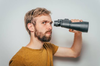 Dürbünlü bir adam. gri arkaplan