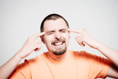 Parmağıyla şakağına dokunan öfkeli bir adamın yakın plan portresi. Delirdin mi sen??