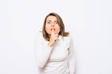 Kadın parmağını dudaklarına koydu.