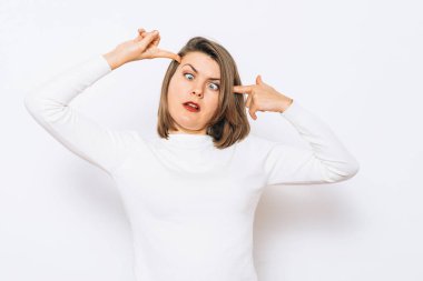 Parmağıyla şakağına dokunan bir kadın..