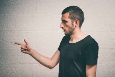 Yakından bakınca genç bir adamın portresi, birini ya da bir şeyi işaret ediyor. Olumlu insan yüzü ifadeleri, duygular, duygular, tutum, yaklaşım