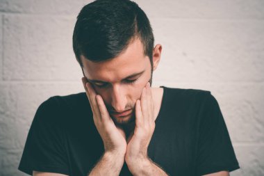 Kafasını elinde tutan genç bir iş adamı