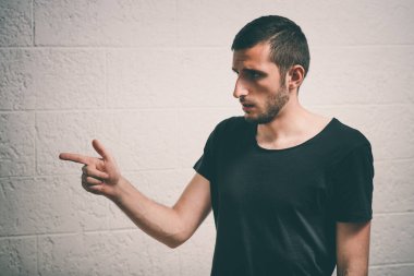 Yakından bakınca genç bir adamın portresi, birini ya da bir şeyi işaret ediyor. Olumlu insan yüzü ifadeleri, duygular, duygular, tutum, yaklaşım