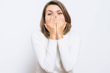 Kız gülüyor ve ağzını kapatıyor.