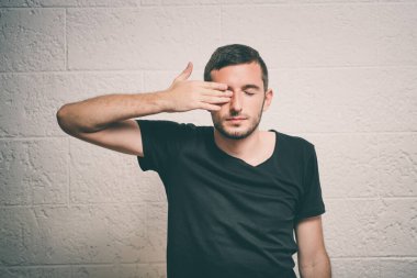  Adam elleriyle yüzünü kapatıyor.