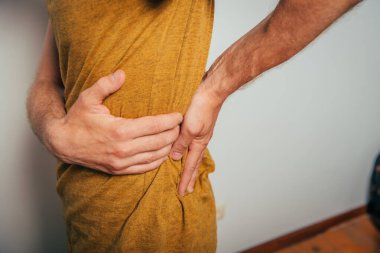 Stüdyo geçmişine karşı sırt ağrısı olan bir adam.