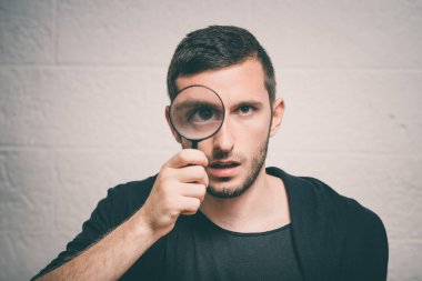 Elinde büyüteç olan adam.