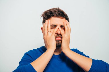 Adam elleriyle yüzünü örttü.