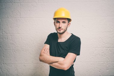 Başında ve kollarında koruyucu miğfer olan yakışıklı bir genç.