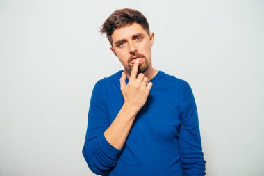 Adam parmağını dilinin üzerine koyar.