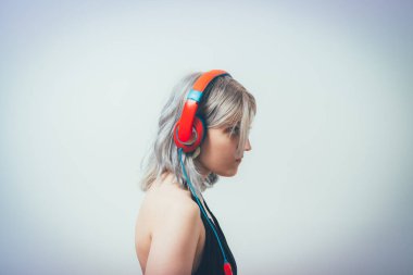 Stüdyo geçmişine karşı kulaklık takan kadın.