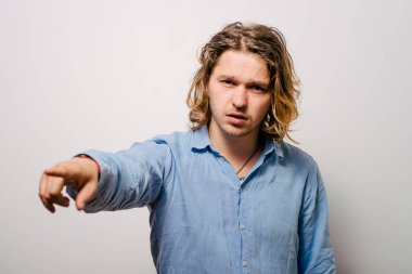 Genç adam işaret parmağını kameraya doğru gösteriyor.