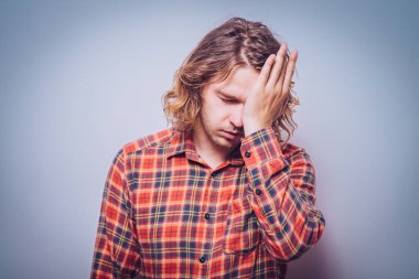  Adam elleriyle yüzünü kapatıyor.