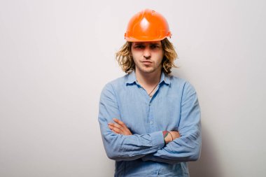 Başında ve kollarında koruyucu miğfer olan yakışıklı bir genç.