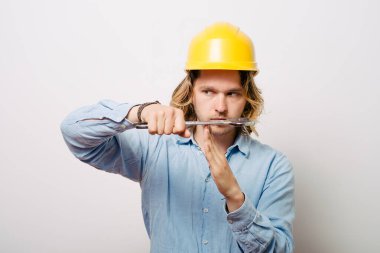 Bir adam, ellerin mola verdiğini gösterir. Gri bir arkaplanda.