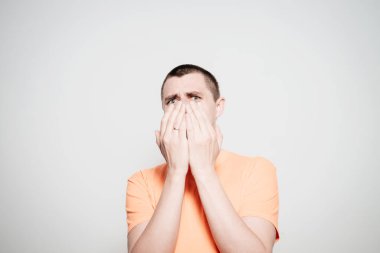 Adam gülüyor ve ağzını kapatıyor.