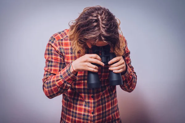 双眼鏡を持ってる 灰色の背景 — ストック写真