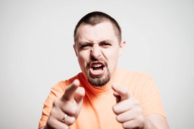 Genç adam işaret parmağını kameraya doğru gösteriyor.