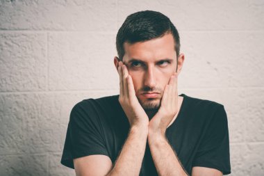 Bitkin düşmüş üzgün bir adam stüdyo geçmişine karşı