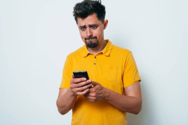 Stüdyo geçmişine karşı akıllı telefonu olan bir adam. 