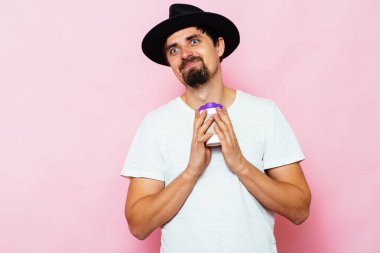 Stüdyonun arka planında fincan olan adam