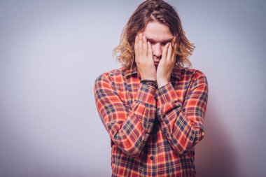 Adam yüzünü kapatıyor.