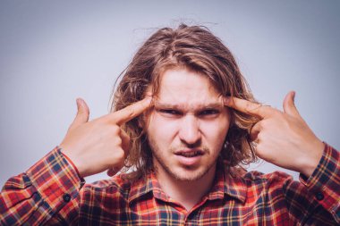 Parmağıyla şakağına dokunan öfkeli bir adamın yakın plan portresi. Delirdin mi sen??