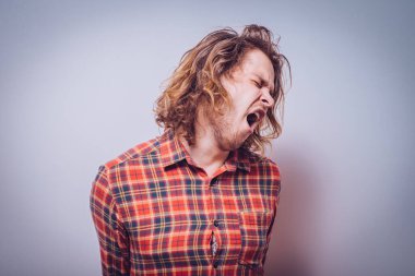 Gri arkaplanda poz veren adam