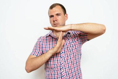 Bir adam, ellerin mola verdiğini gösterir. Gri bir arkaplanda.