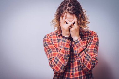 Adam yüzünü kapatıyor.