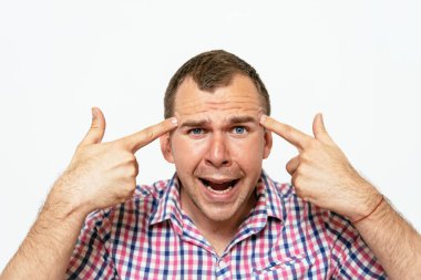 Parmağıyla şakağına dokunan öfkeli bir adamın yakın plan portresi. Delirdin mi sen??