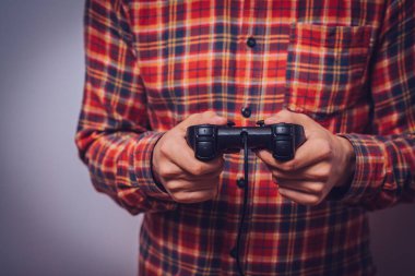 Oyun konsolunda oyun çubuğunda oynayan adam