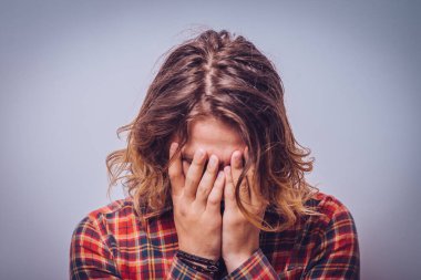 Adam yüzünü kapatıyor.