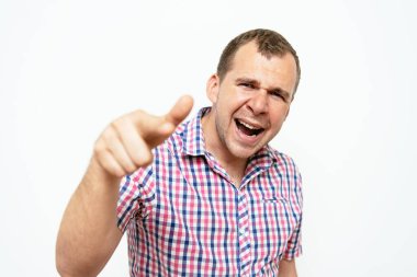 Genç adam işaret parmağını kameraya doğru gösteriyor.