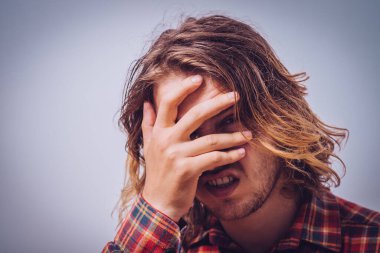  Adam elleriyle yüzünü kapatıyor.