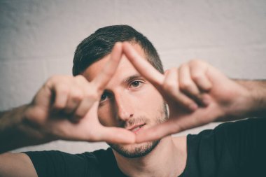 Adam stüdyo arka planında çerçeve yapıyor.