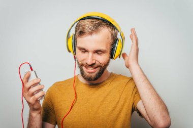 Kulaklıklı bir adam stüdyo geçmişine karşı. 