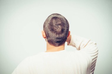 Kafasını tutarak. Arkadaki adam