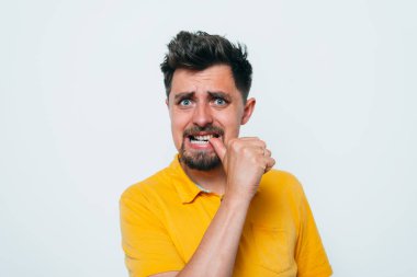 Adam tırnaklarını stüdyonun arka planında yiyor. 