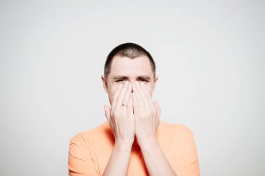 Adam gülüyor ve ağzını kapatıyor.