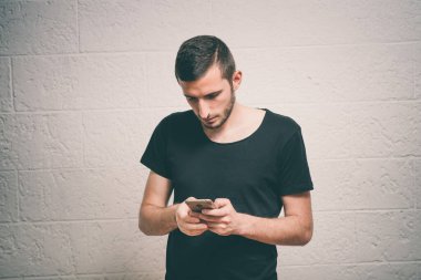 Stüdyo geçmişine karşı akıllı telefonu olan bir adam.