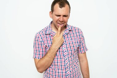 Avrupa görünümlü erkek kusmaya neden olur. Parmaklarını gri arka planda tutar, bulantıya neden olur.